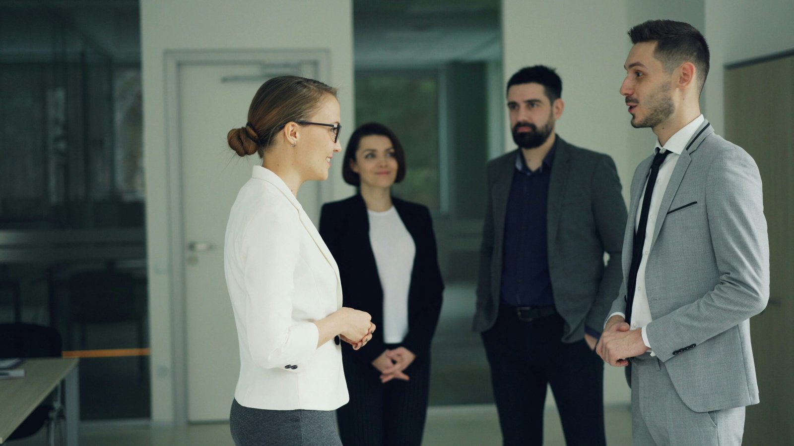 recruteur et candidat qui discutent dans un bureau entourés de collègues